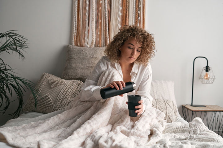 home brewing coffee - woman in bed pours coffee - go joe bean